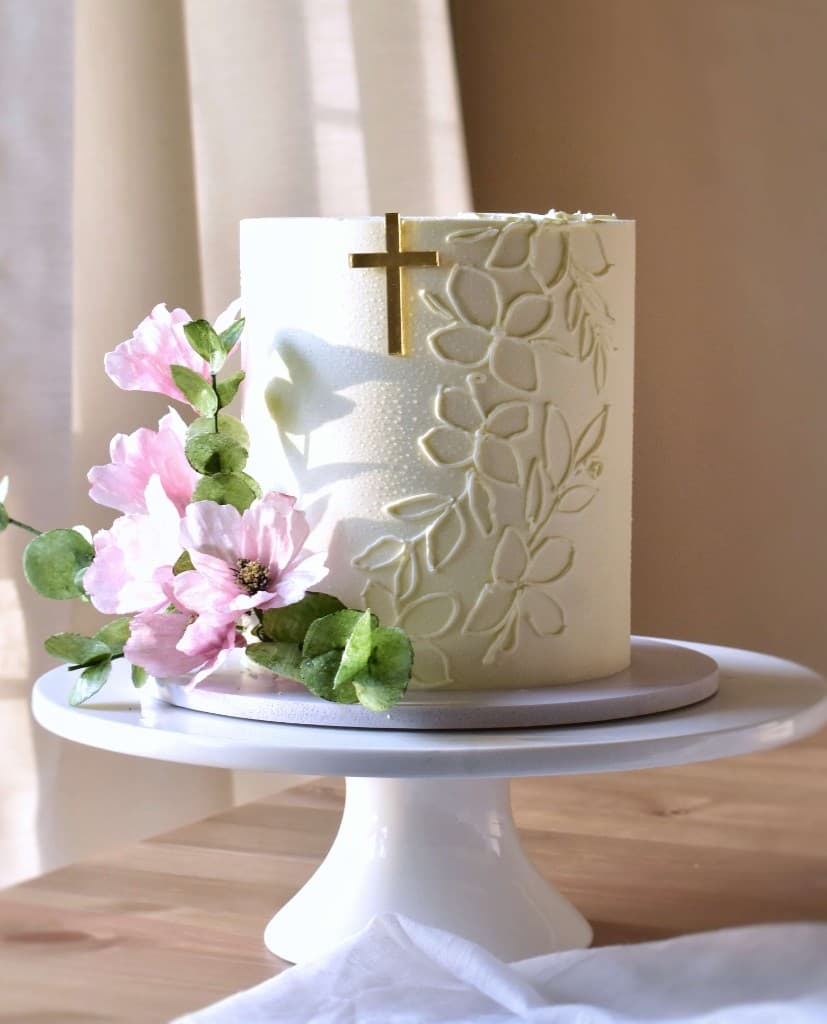 Wedding cake with gold cross and pink flowers