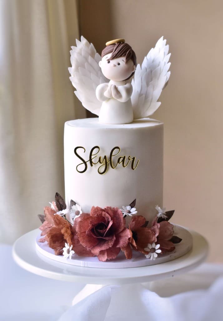 Baptism cake with angel topper and florals