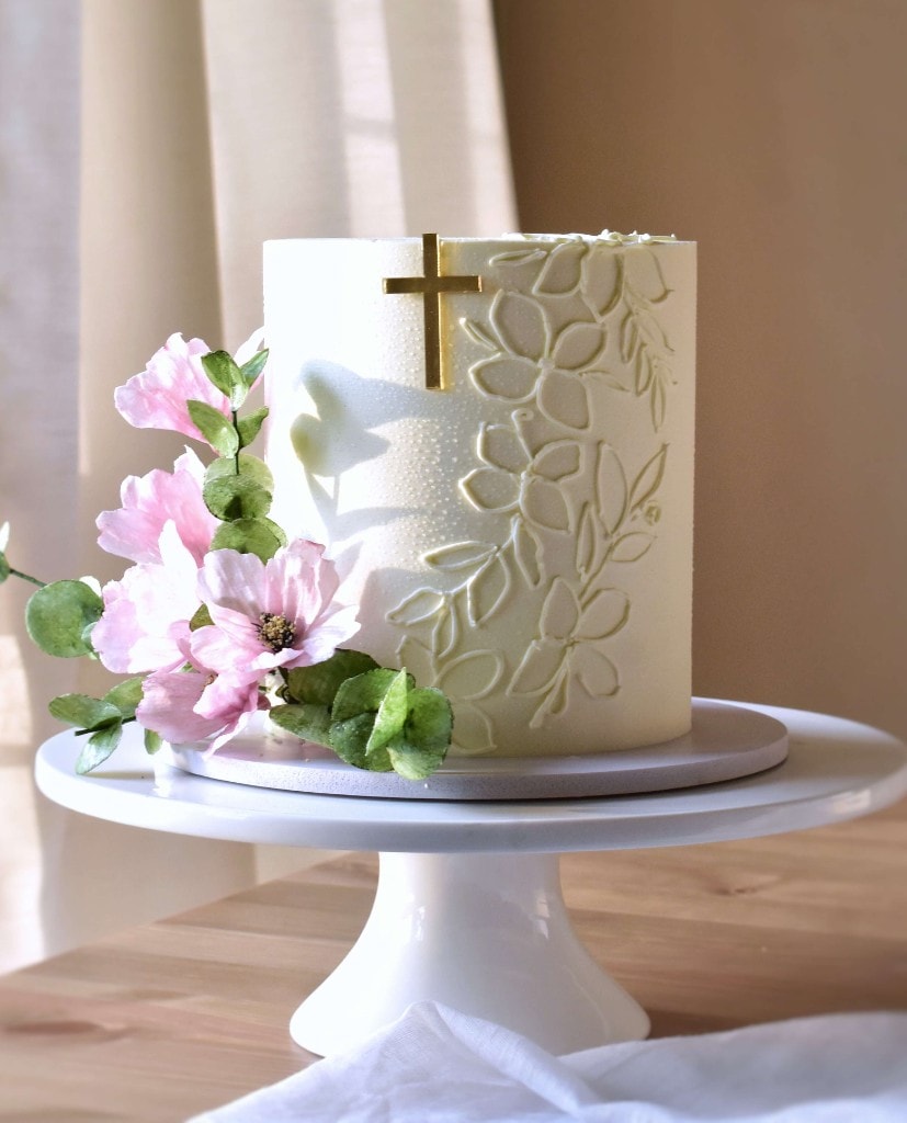 Wedding cake with gold cross and pink flowers